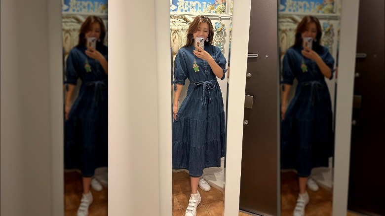 Woman wearing denim dress, sneakers