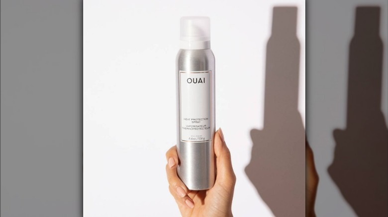 Silver ouai bottle being held