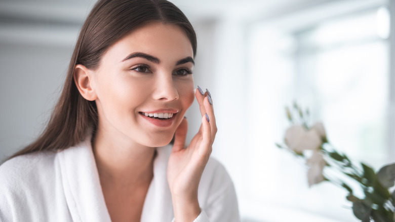 woman smudging makeup on cheeks