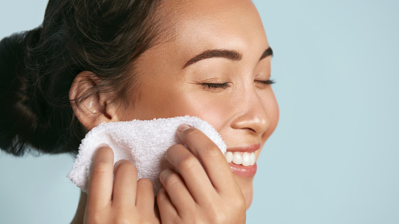 woman removing her makeup with cloth