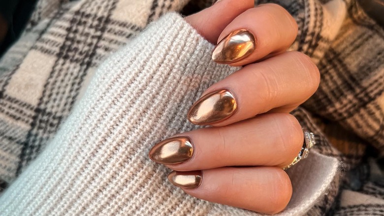 hand with gold chrome nails