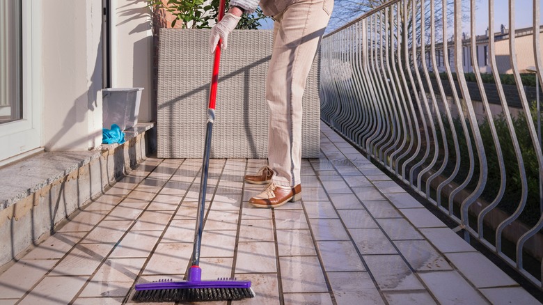 woman sweeping a balcony