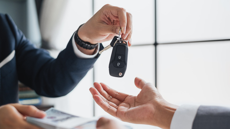 person handing off car keys