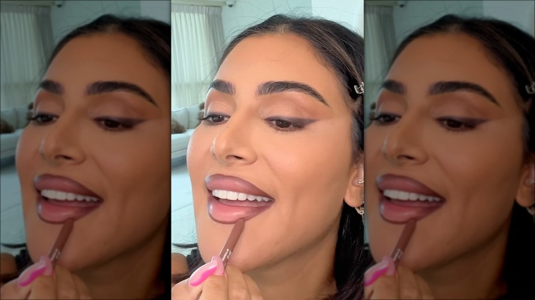 Huda Kattan applying lipstick