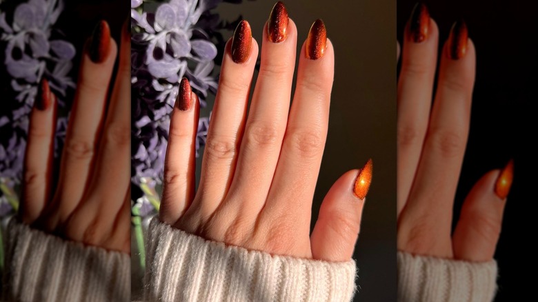 Burnt orange nail art on fingers