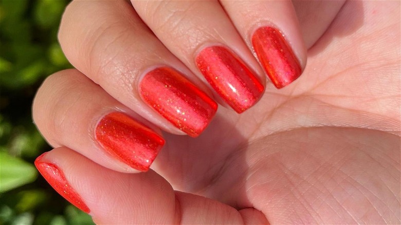 Shimmery red to orange nails