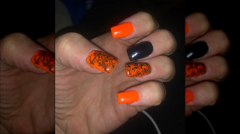 orange and black nails on fingers