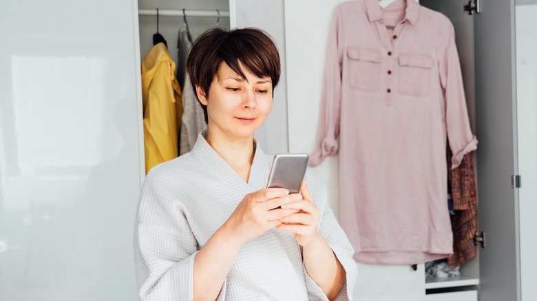 woman on her phone in front of her closet