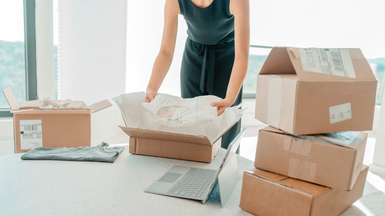 woman packing clothes in boxes