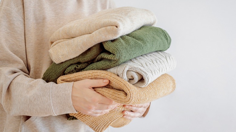 woman holding a pile of clothes