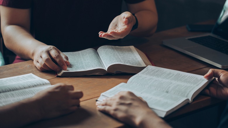 three people reading the bible