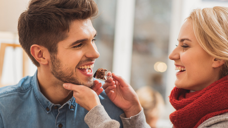 Couple happily eating cake