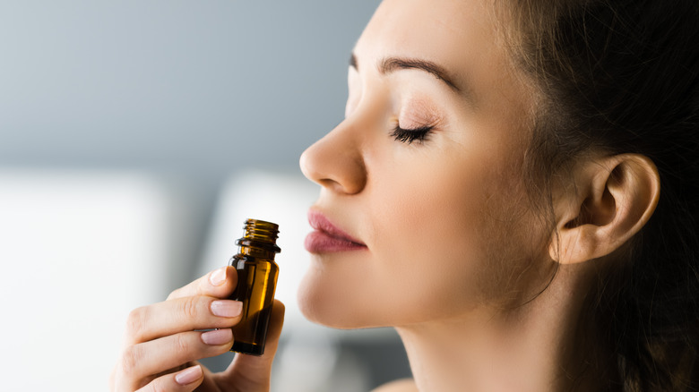 a woman smelling essential oil