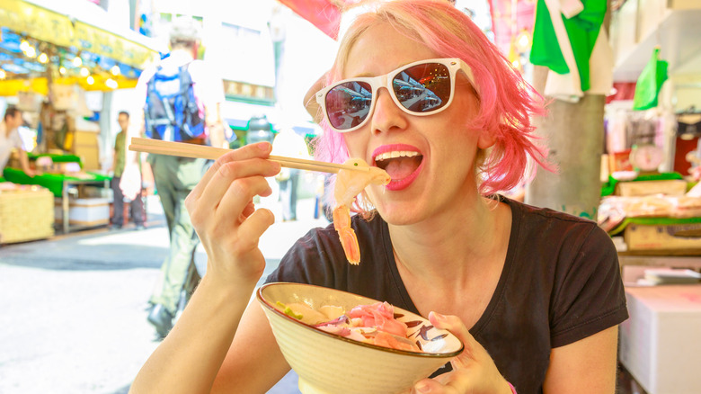 woman eating bowl of food