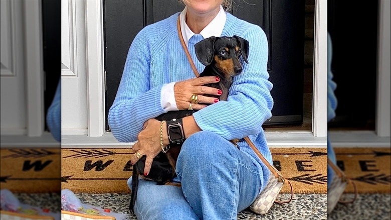 Woman in blue sweater, white button-up, jeans