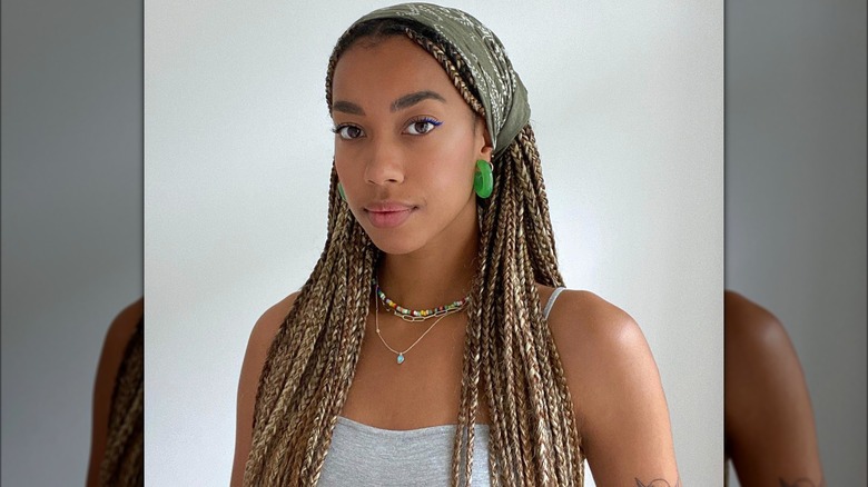 A woman with a bandana over her braids
