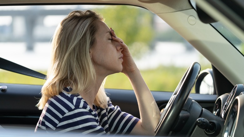 woman in car looking overwhelmed
