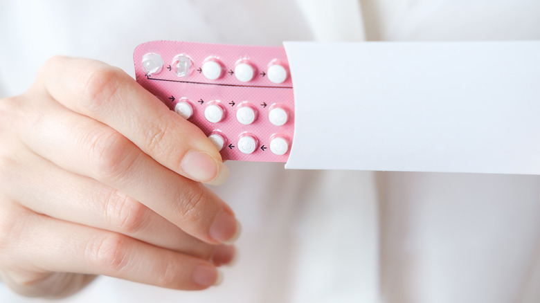 hand holding birth control pills