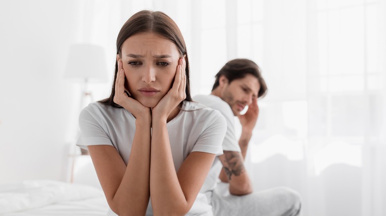 woman concerned sitting on bed