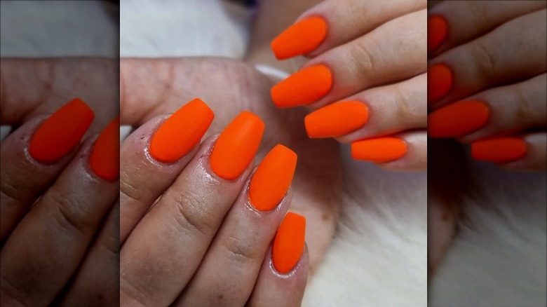 woman with bright orange nails