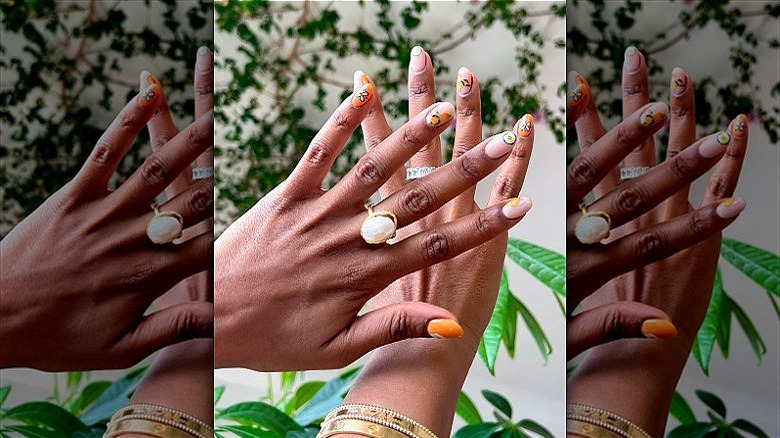 woman with orange floral nails