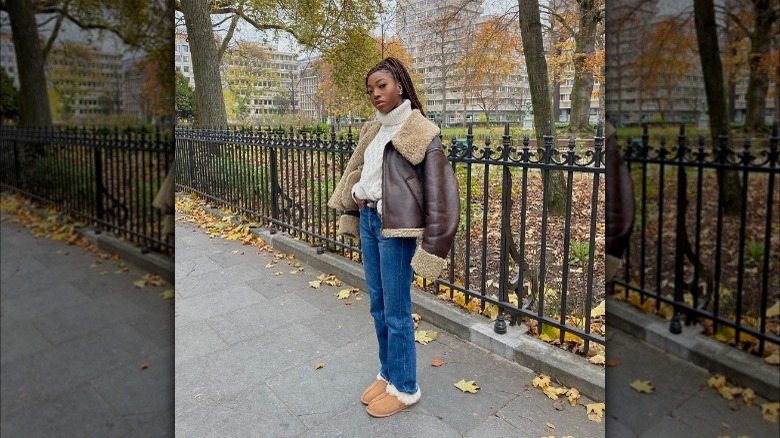 Woman wearing leather sherpa jacket and Uggs