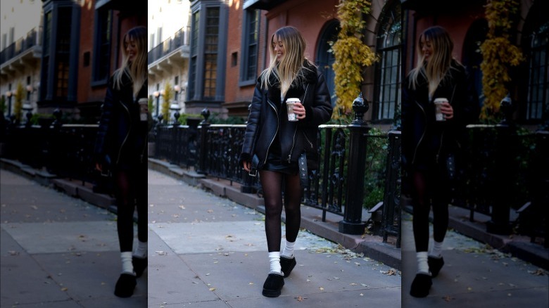 Woman wearing a miniskirt, black tights, and Uggs