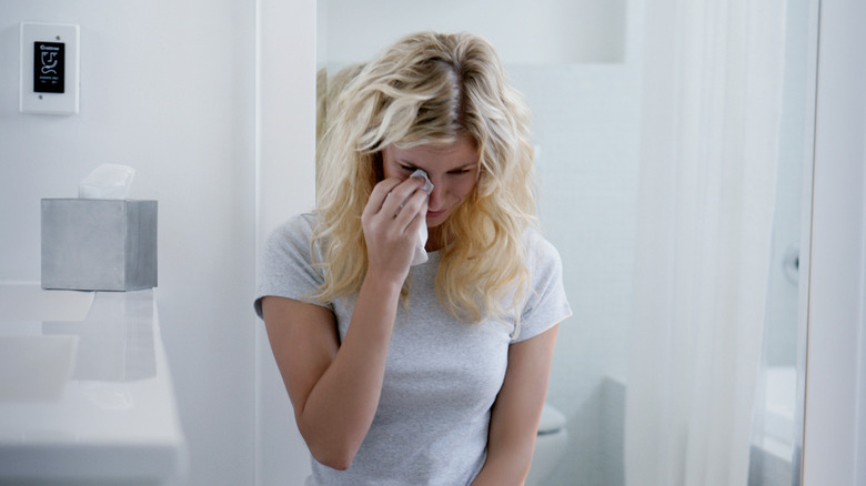 woman wiping tear away with napkin