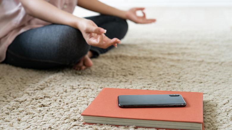 Woman meditating with phone down 