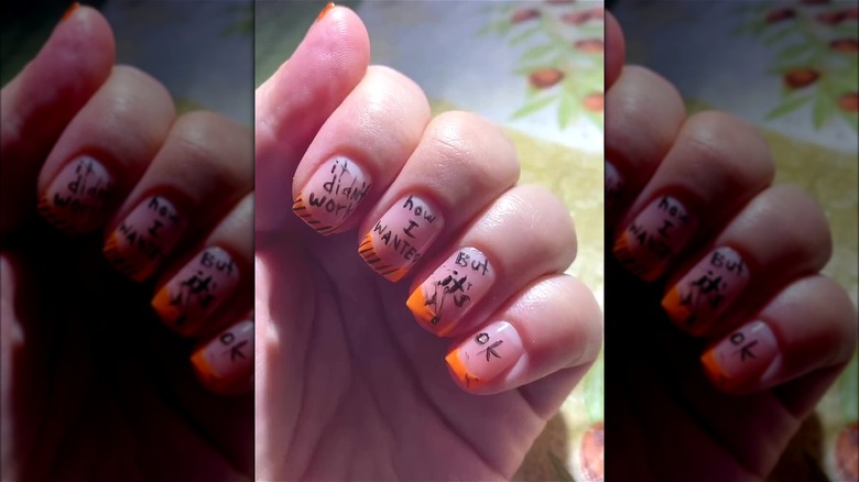 Natural nails with orange and black ink