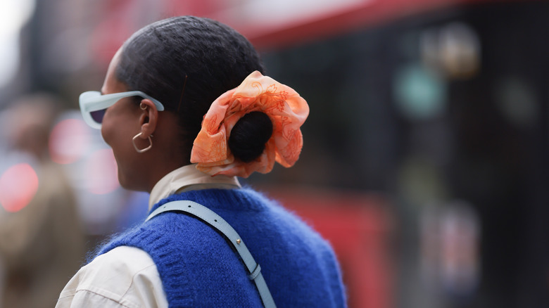 woman wearing big orange scrunchie 