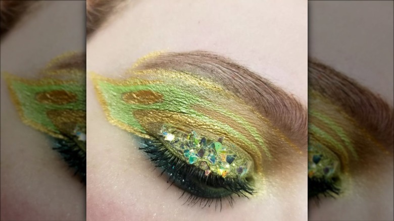 woman wearing green bejeweled graphic eyeliner