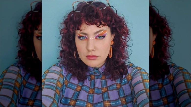 woman wearing white orange purple graphic eyeliner