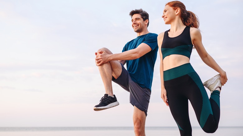 Two people stretching before jogging