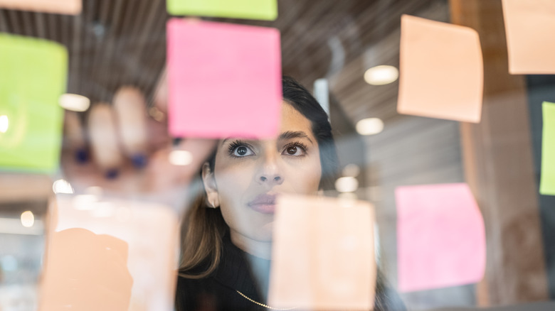 Woman looking at Post-it notes