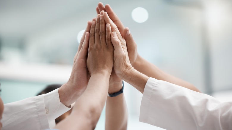 Group of people high-fiving each other