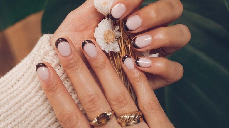 hands with glittery brown french manicure