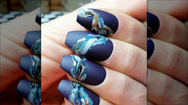 hand with blue coffin nails