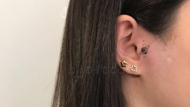 saturn tiny ear tattoo