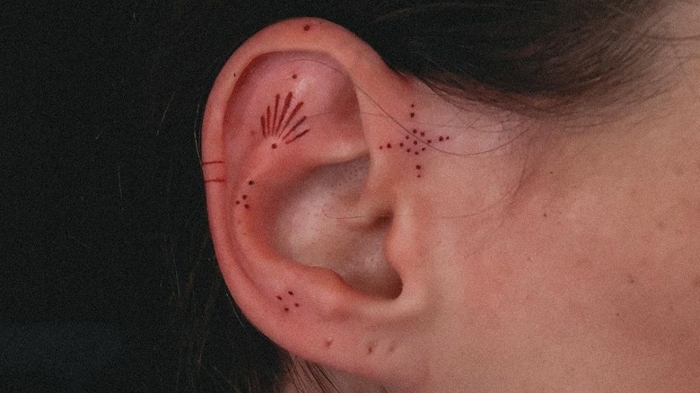 red ink ear tattoo