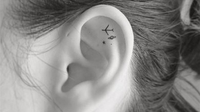 planet star plane ear tattoo