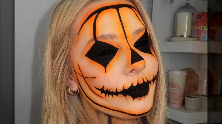 Woman wearing jack-o-lantern makeup