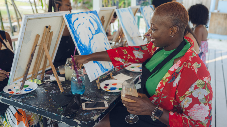 woman enjoying a wine and paint gathering