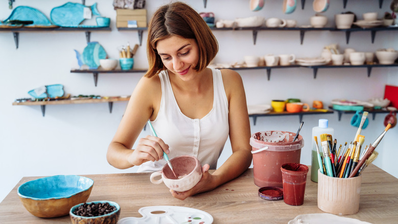 woman painting a cup 