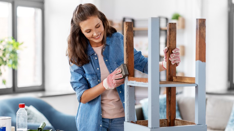 woman upcycling a wood chair