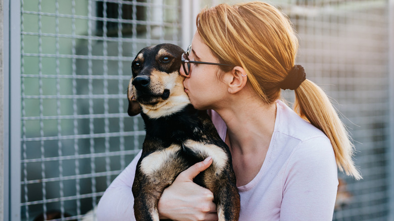 woman hugging and kissing dog