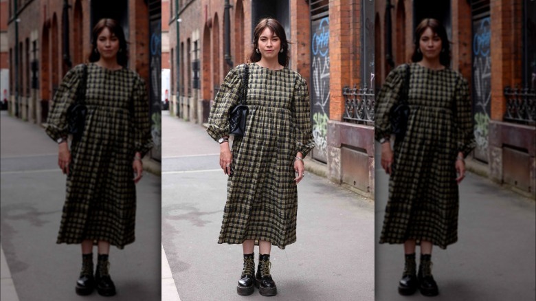 Woman wearing checkered midi dress and Doc Martens