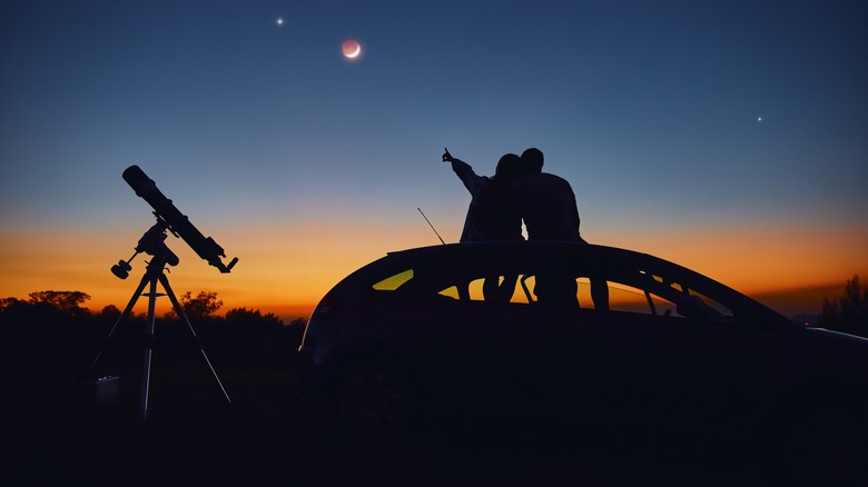 couple stargazing with telescope