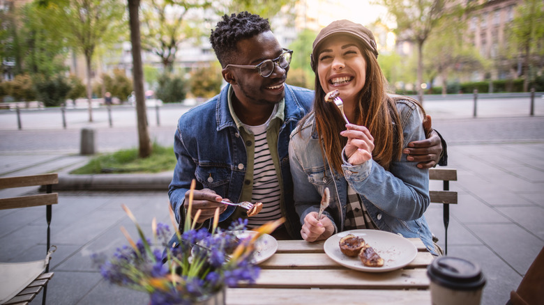 couple sitting outside at cafe in city