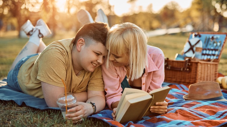 couple reading on blanket in park